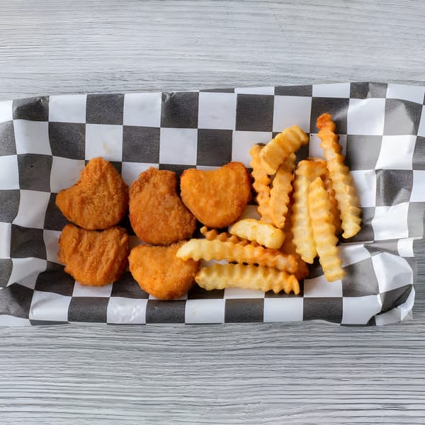 Crispy chicken nuggets and crinkle-cut fries served in a checkered paper tray.