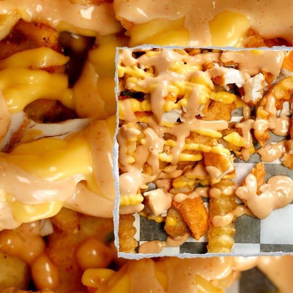 Close-up of Slaw Burger's loaded fries with melted cheese, chicken pieces, and special sauce.
