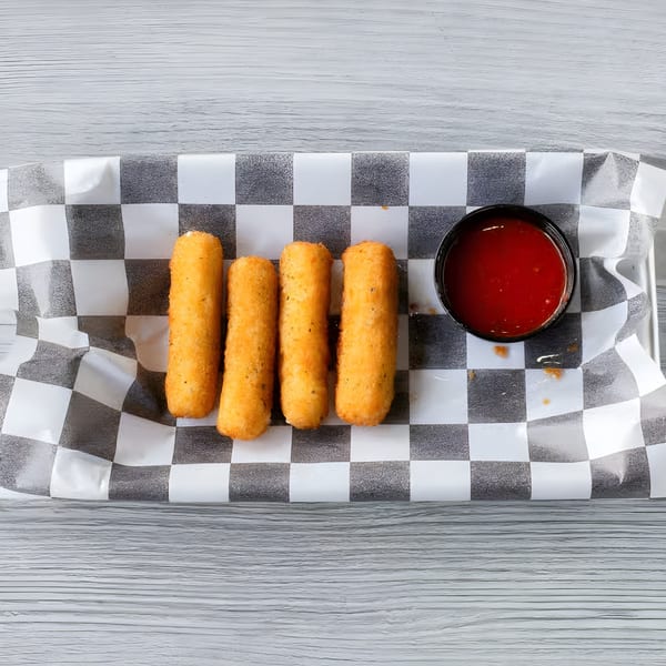 Four golden-brown mozzarella sticks and a small cup of red dipping sauce on checkered paper.