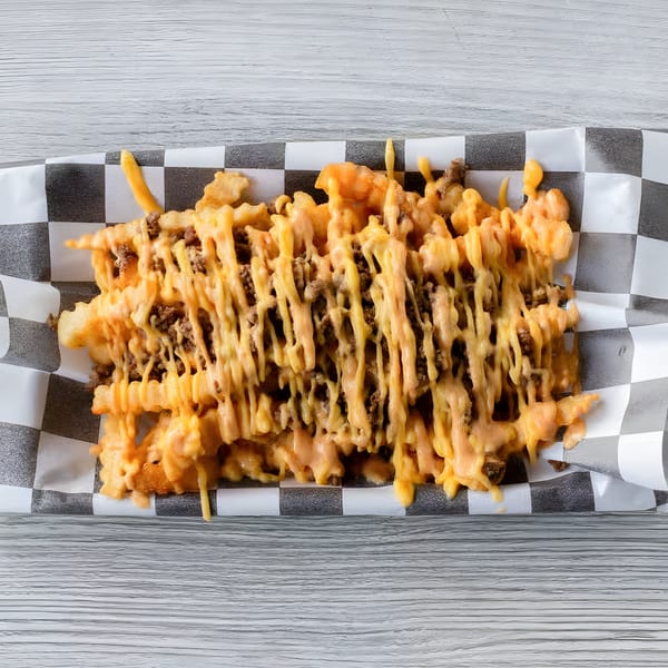 Slaw Burger's waffle fries topped with melted cheese and ground beef, served in a checkered paper tray.